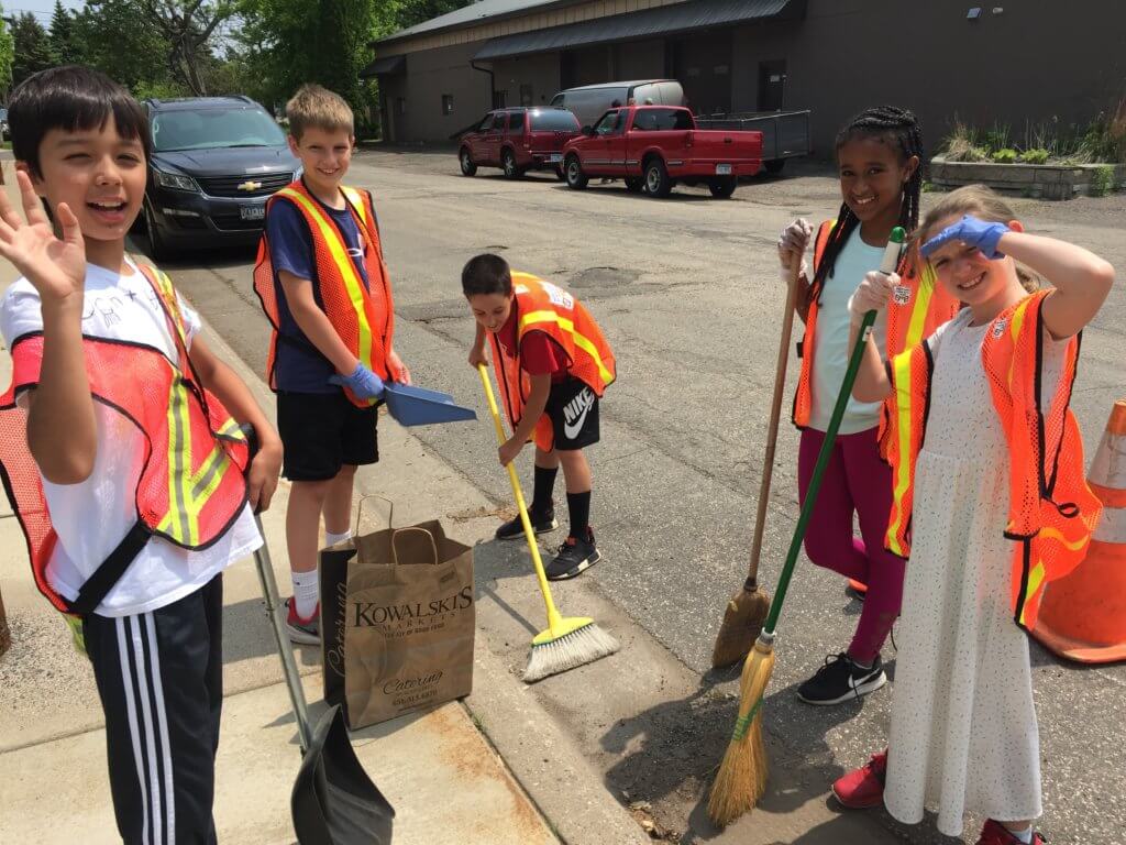 Kids cleaning a storm drain.